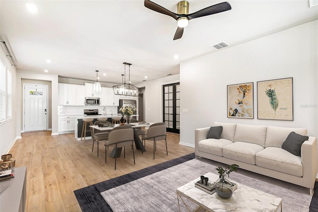 living room featuring ceiling fan and light wood-type flooring