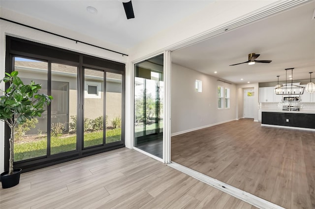 unfurnished living room with light wood-type flooring and ceiling fan