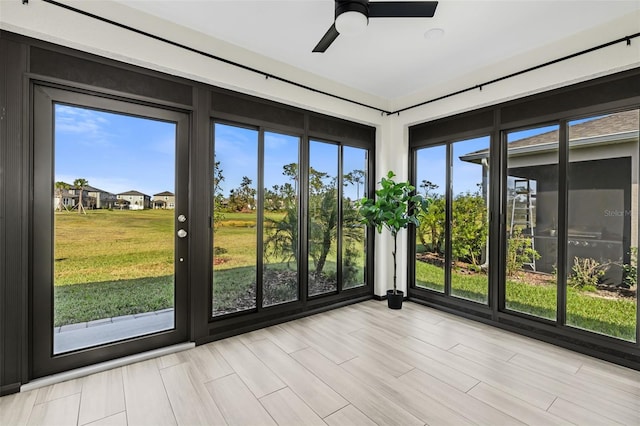 unfurnished sunroom featuring ceiling fan and a healthy amount of sunlight