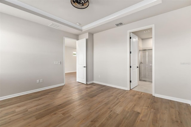 unfurnished bedroom featuring connected bathroom and wood-type flooring