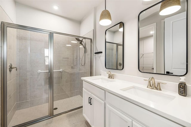 bathroom featuring tile patterned floors, vanity, and a shower with door