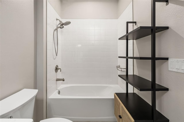 bathroom featuring toilet and tiled shower / bath