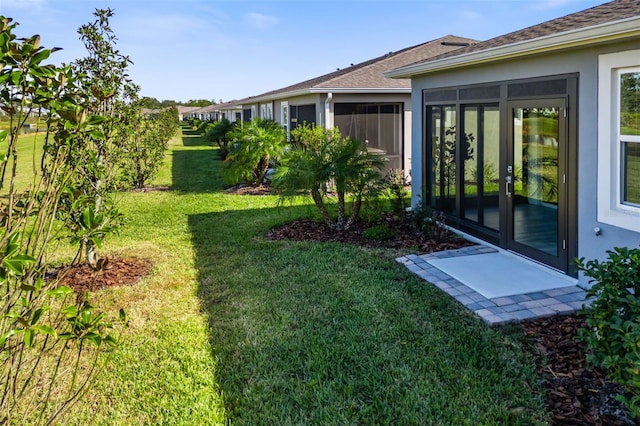 view of yard featuring french doors and a sunroom