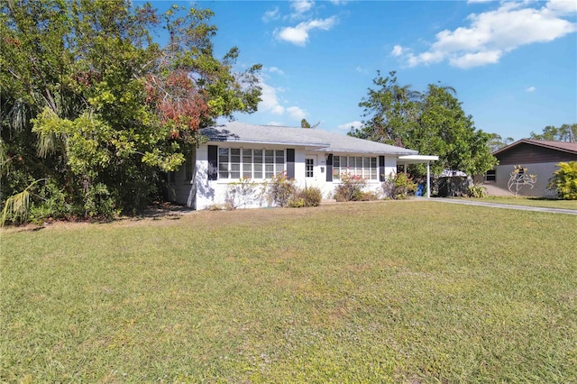 view of front of property with a front yard and a carport