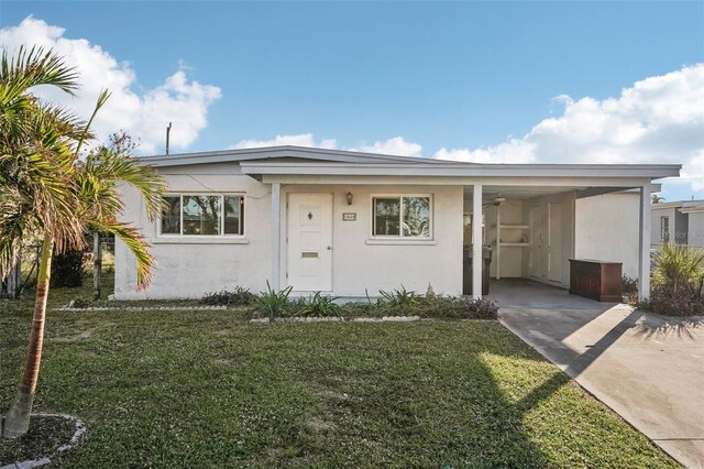 view of front of home with a front yard and a carport