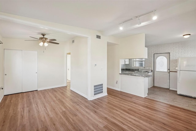 kitchen featuring white cabinets, light wood-type flooring, white appliances, and rail lighting