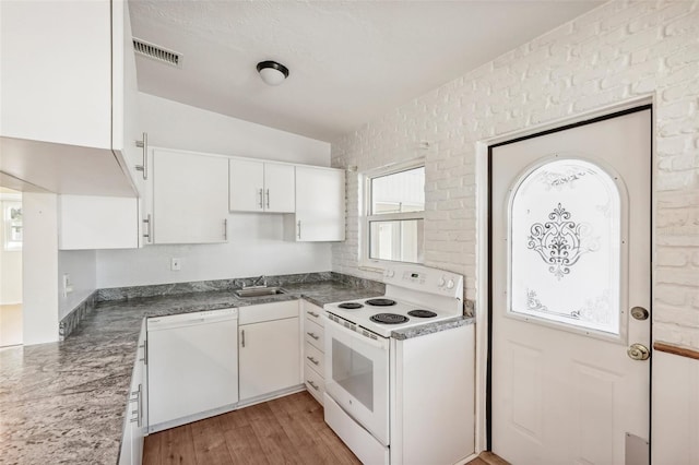 kitchen featuring white cabinetry, sink, light hardwood / wood-style floors, vaulted ceiling, and white appliances