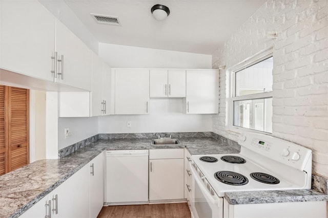 kitchen featuring white appliances, vaulted ceiling, sink, white cabinets, and light hardwood / wood-style floors