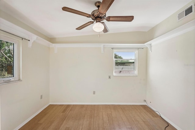 spare room featuring light wood-type flooring, lofted ceiling, ceiling fan, and a healthy amount of sunlight