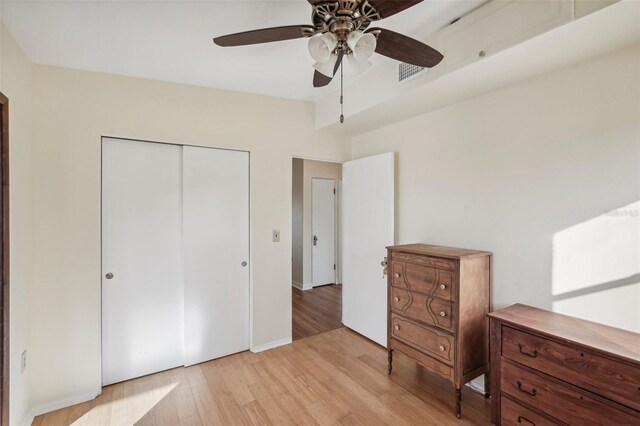 bedroom with ceiling fan, a closet, and light hardwood / wood-style flooring