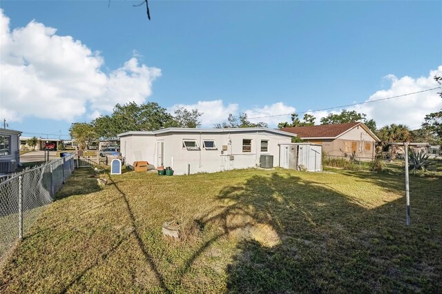 back of property featuring a lawn and central air condition unit