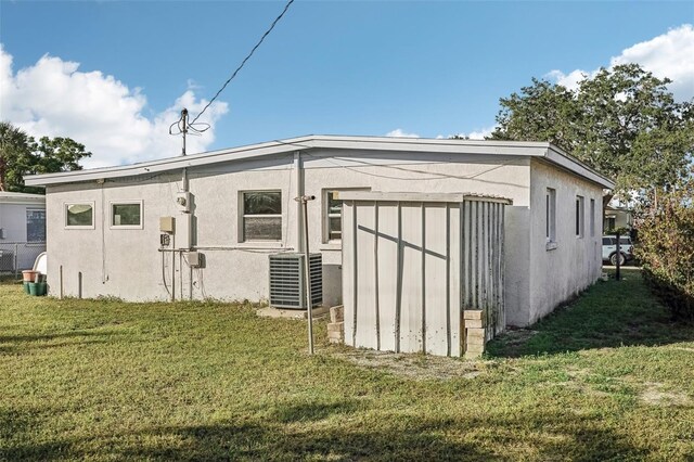 view of outbuilding featuring central AC unit and a yard