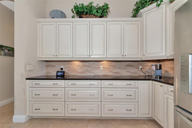 kitchen with white cabinets, decorative backsplash, and light tile patterned floors