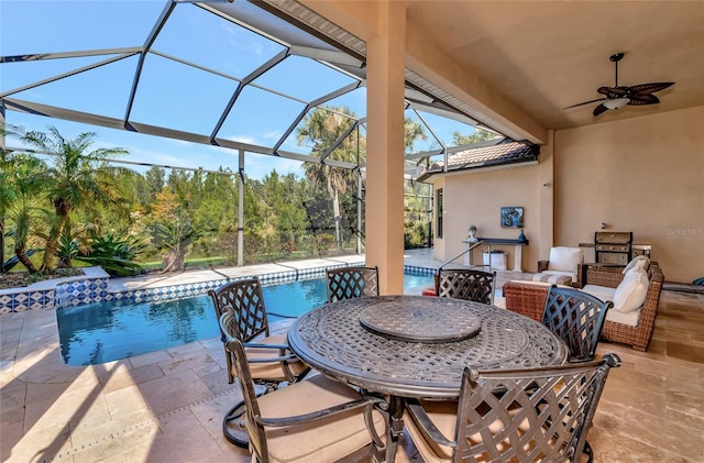 view of patio with ceiling fan and glass enclosure