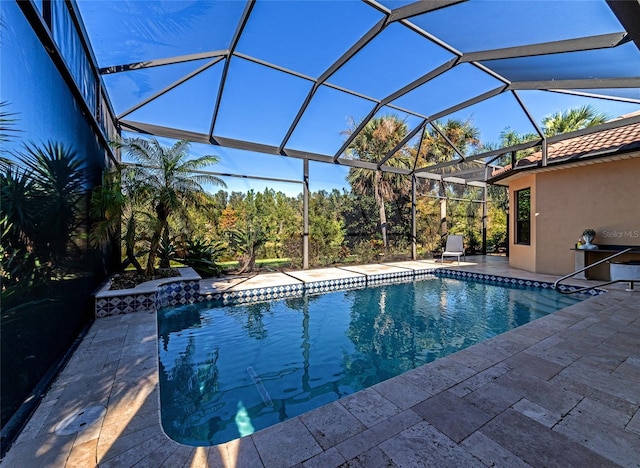 view of swimming pool featuring glass enclosure and a patio area