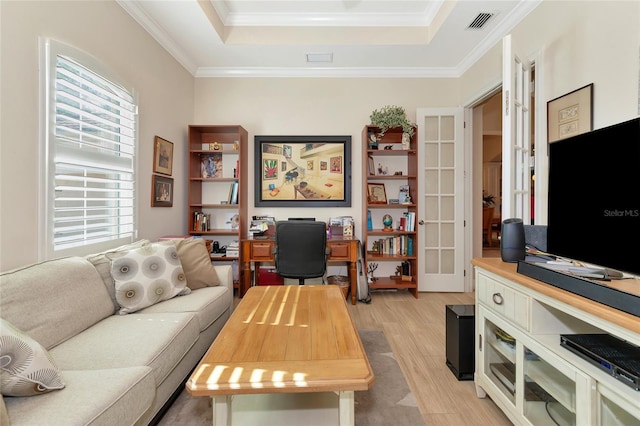 living room with french doors, light hardwood / wood-style flooring, a raised ceiling, and crown molding