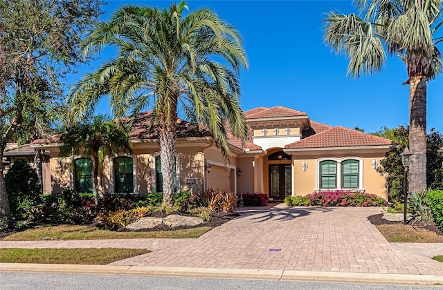 mediterranean / spanish home featuring french doors and a garage