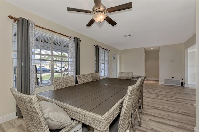 dining space with ceiling fan and light wood-type flooring