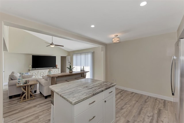 kitchen featuring stainless steel fridge, light wood-type flooring, ceiling fan, white cabinets, and a kitchen island