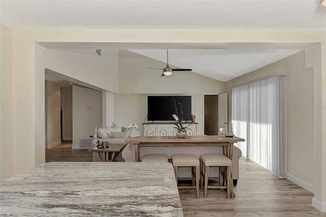 kitchen with ceiling fan, light hardwood / wood-style flooring, and vaulted ceiling