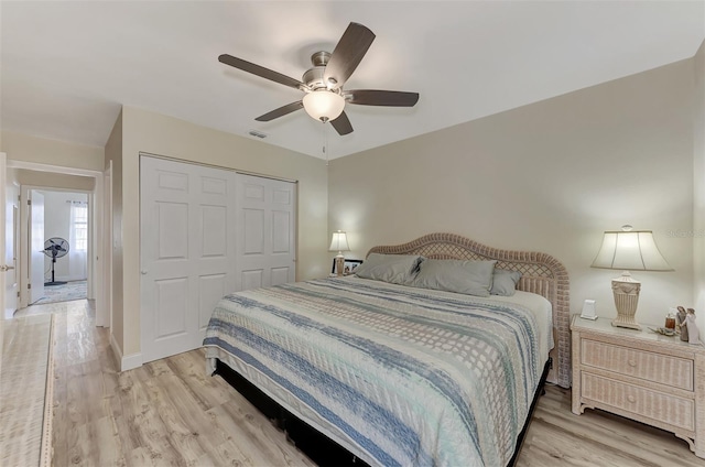 bedroom with ceiling fan, a closet, and light hardwood / wood-style floors