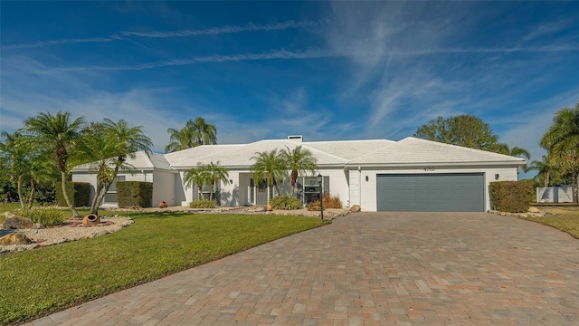 single story home featuring a garage and a front lawn