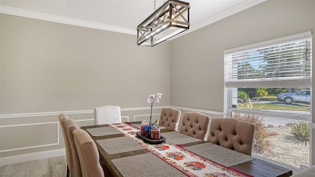 dining area with crown molding, wood-type flooring, and a notable chandelier