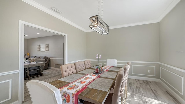 dining room with light hardwood / wood-style flooring and ornamental molding