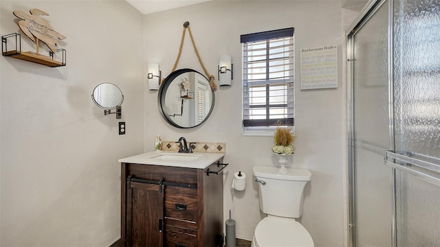 bathroom featuring vanity, toilet, and walk in shower