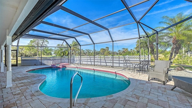 view of pool with an in ground hot tub, glass enclosure, and a patio area