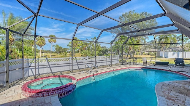 view of pool featuring glass enclosure, an in ground hot tub, and a patio area