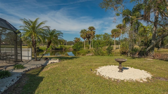 view of yard featuring glass enclosure and a water view