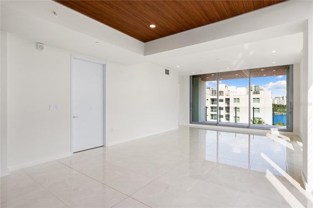 spare room with floor to ceiling windows and wooden ceiling