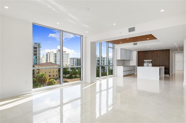 unfurnished room with floor to ceiling windows and light tile patterned flooring