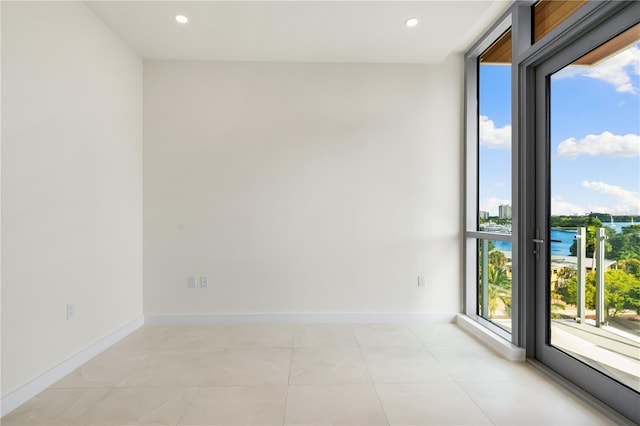 tiled spare room featuring a water view