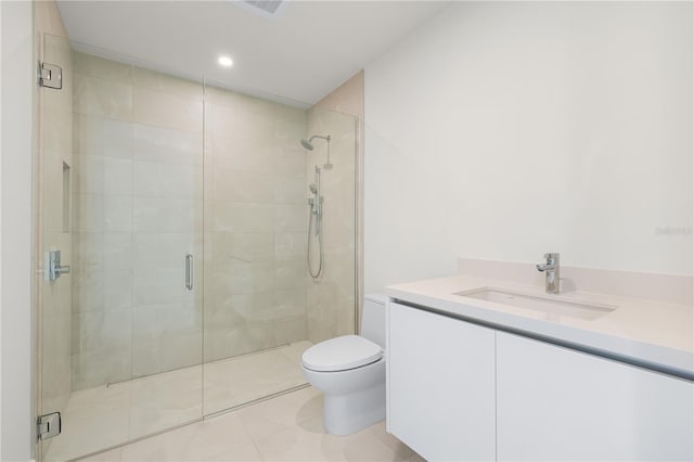 bathroom with tile patterned floors, vanity, a shower with shower door, and toilet