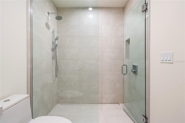 bathroom with an enclosed shower and toilet