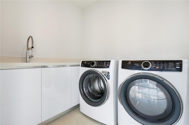 clothes washing area featuring cabinets and separate washer and dryer