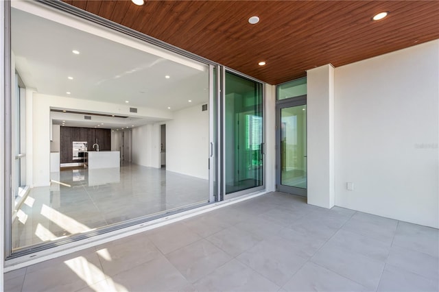 unfurnished room featuring a wall of windows and wood ceiling