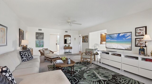 carpeted living room with ceiling fan