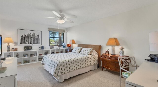 carpeted bedroom featuring ceiling fan and a textured ceiling