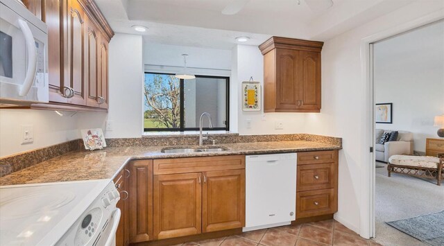 kitchen featuring light colored carpet, white appliances, and sink