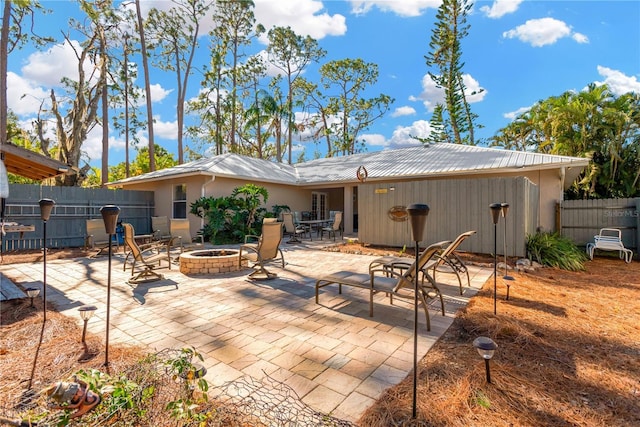 back of property featuring a patio and an outdoor fire pit