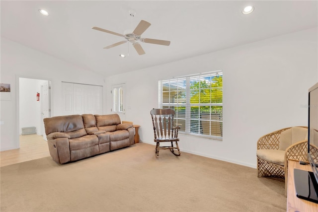 carpeted living room with ceiling fan and high vaulted ceiling