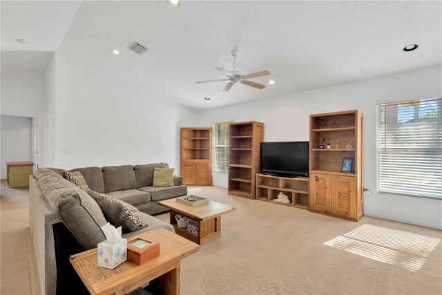 living room with light carpet, vaulted ceiling, and ceiling fan