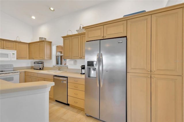 kitchen featuring light brown cabinetry, sink, light hardwood / wood-style flooring, and appliances with stainless steel finishes