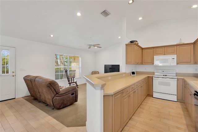 kitchen with a healthy amount of sunlight, white appliances, kitchen peninsula, and vaulted ceiling