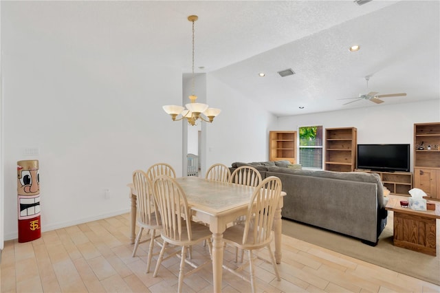 dining area featuring ceiling fan with notable chandelier, a textured ceiling, light wood-type flooring, and lofted ceiling