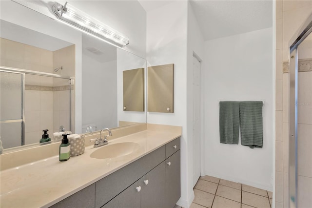 bathroom with tile patterned floors, a shower with door, and vanity