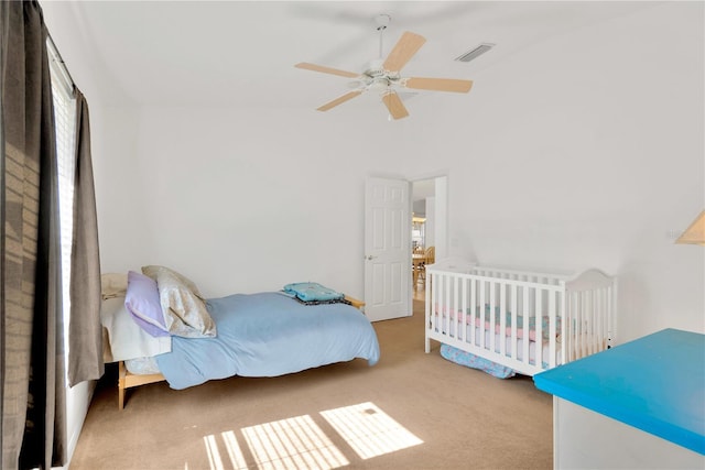 bedroom with ceiling fan, light colored carpet, multiple windows, and vaulted ceiling